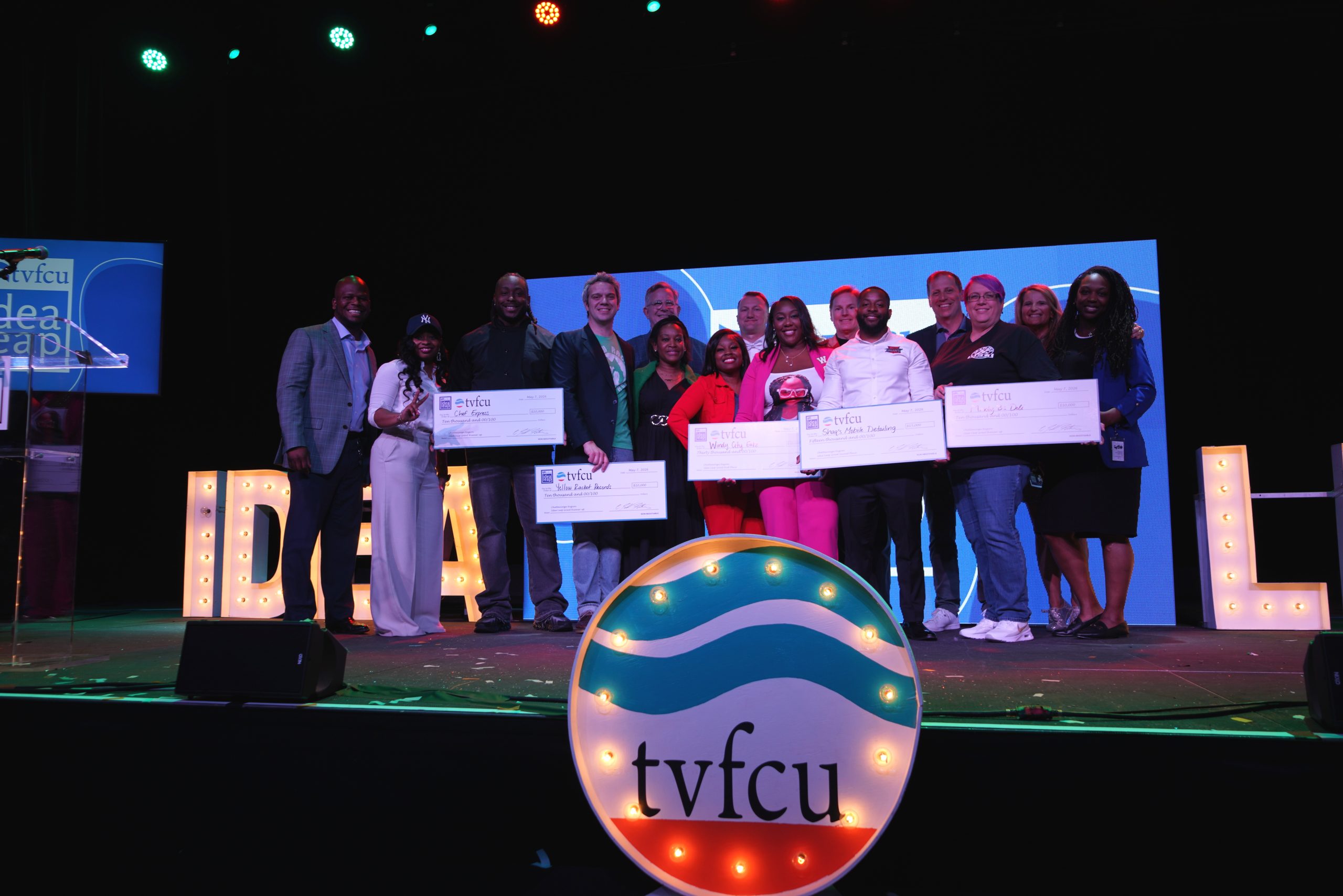Grant winners posing on stage with award checks.