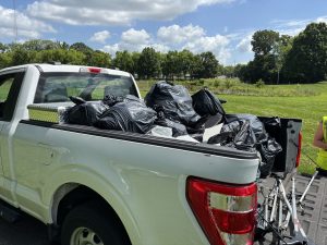 Pickup truck bed full of bags of trash.